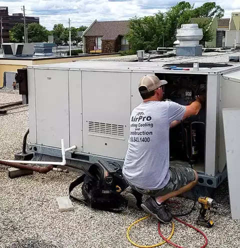 An AirPro tech hard at work fixing a commercial HVAC unit